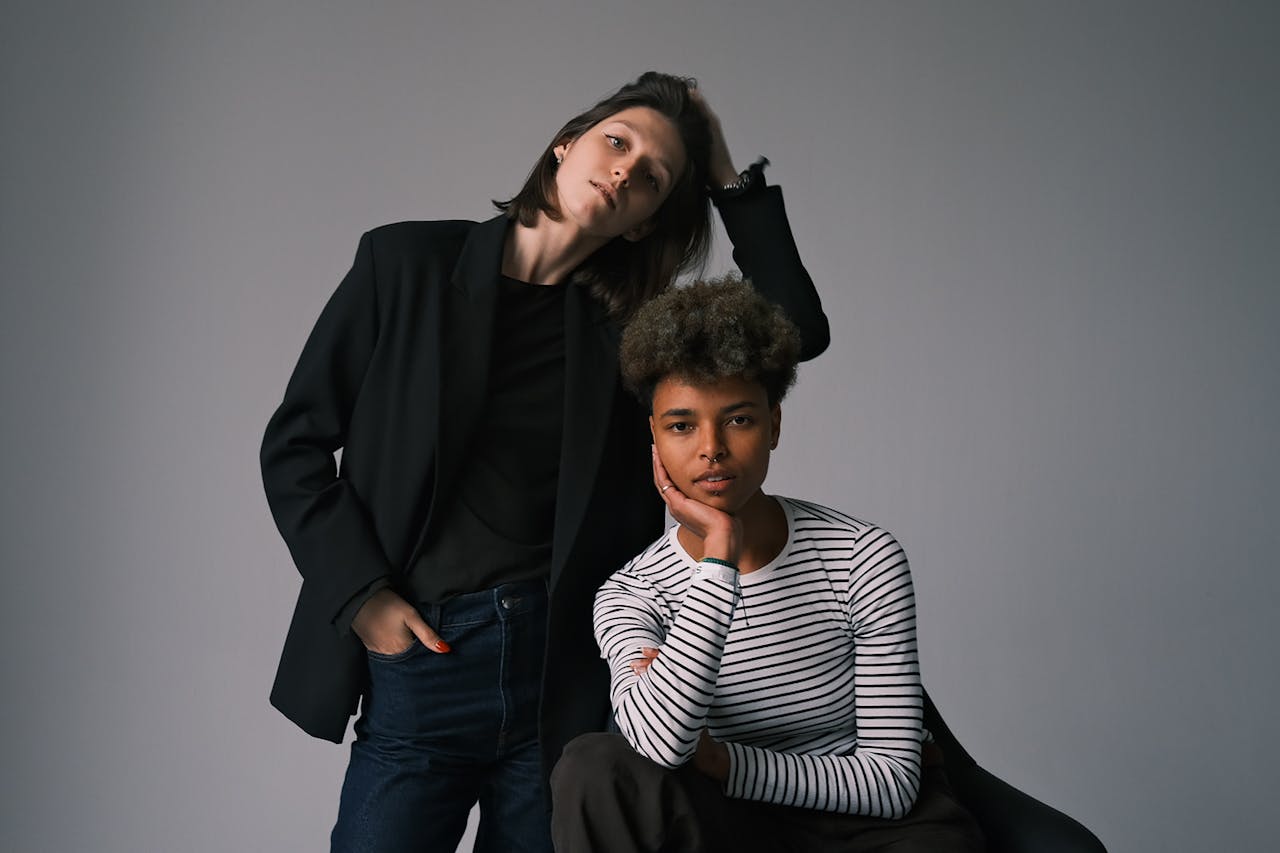 about-01 A modern portrait of two stylish adults in casual and elegant attire posing indoors.
